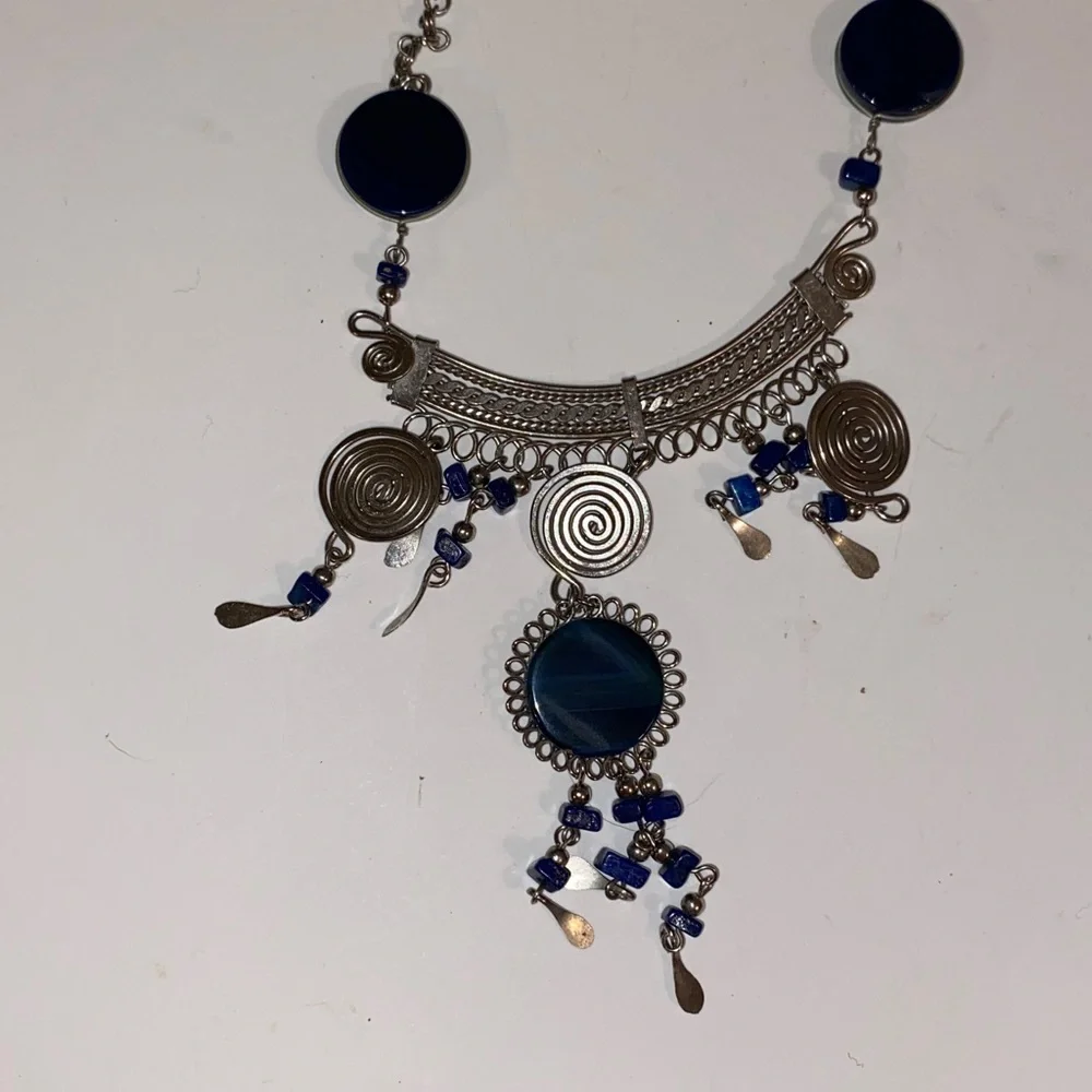Ornate Silver-Toned Necklace with a Curved Center Adorned with Blue/Black Stones